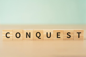征服・克服のイメージ｜「CONQUEST」と書かれたブロック

