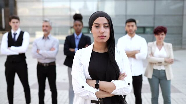 team of business people standing together,focus on Muslim woman in hijab happy smiling with folded arms