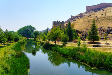 Fototapeta na wymiar Ucero river passing quietly next to the wall of the medieval city of Burgo de Osma, Soria.