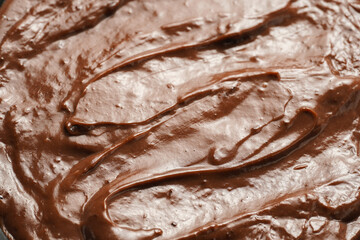 a close-up on chocolate ganache or pudding with swirls and spreads filling the frame, selective focus
