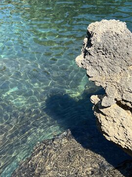 Cliff against turquoise sea water. Scenic rocky coast of the sea.