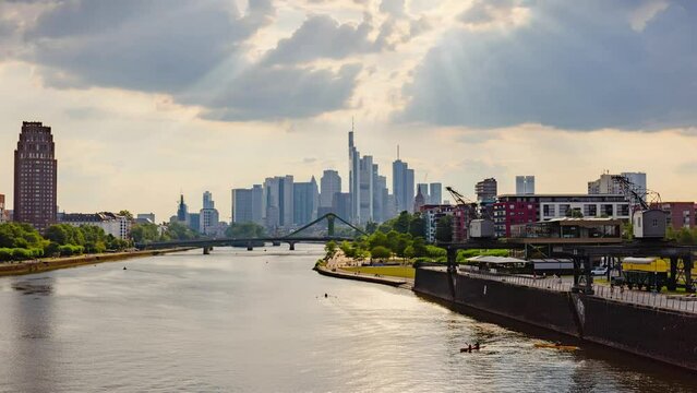 Frankfurt skyline hyperlapse time lapse, blue sky with clouds, office buildings and skyscraper in center with river and bridges in the foreground, Frankfurt am Main, Hessen, Germany