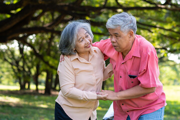 Asian senior man falling down on lying floor at park after Stumbled  and Crying in pain and him wife came to help support. Concept of old elderly insurance and health care