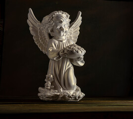 Guardian angel isolated black background statue copy space beautiful holy wings bowl of roses flower in hand