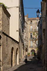 Scenic urban landscape view of ancient narrow alley with old buildings in the historic center of Montpellier, France	