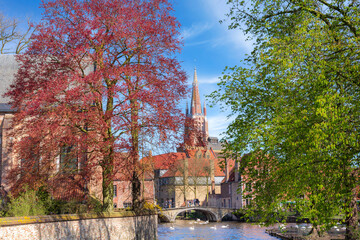 Fototapeta premium Canal and bridge view, church in Bruges, Belguim