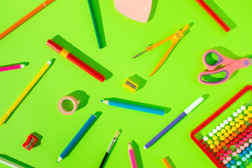 School supplies set on bright green background. Creative school or office stationery concept. Flat lay.