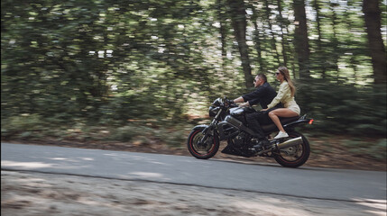 Blurred Motion Young couple on a motorcycle no helmet ride on the road at high speed, dangerous...
