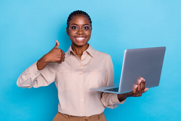 Photo of cheerful businesswoman recommend rate laptop gadget show thumb-up isolated on blue color background