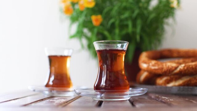 Turkish breakfast, turkish tea and simit, sesame bagel and potted plant on wooden table