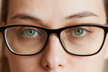 Close-up of a young woman's eye in glasses. Vision correction concept, spectacle frame