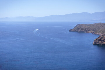 Hypnotic sea horizon with small islet Spinalonga, mountain hills and speed boat's movement in  blue...