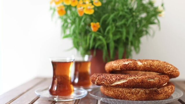 Turkish breakfast, turkish tea and simit, sesame bagel and potted plant on wooden table