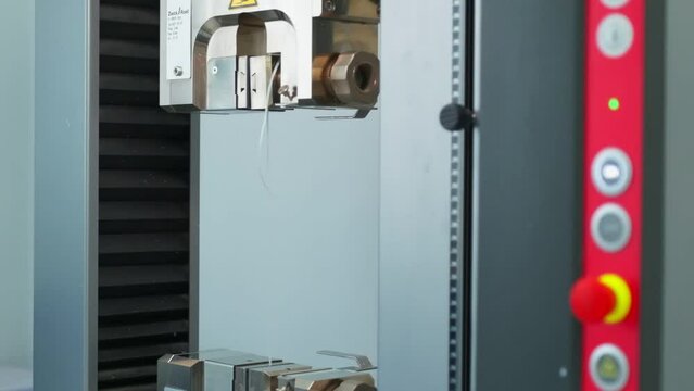 Polymer thread for plastic sack bags is tested for strength in laboratory, slow motion