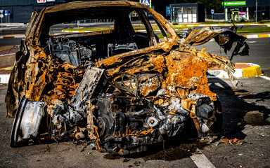 Bucha, Ukraine - May 22, 2022: a car burned in the bombed-out yard. Consequences of the occupation of a peaceful city by Russian troops