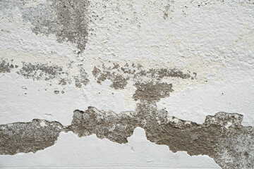 Close up white color painted old peeling or failing cracked plaster wall concrete grunge texture background