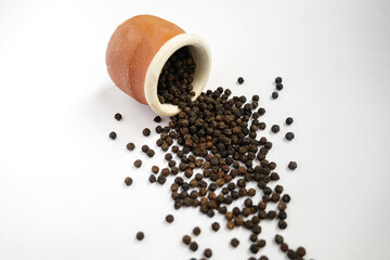 Black peppercorn on a white background- Indian dried spices.
