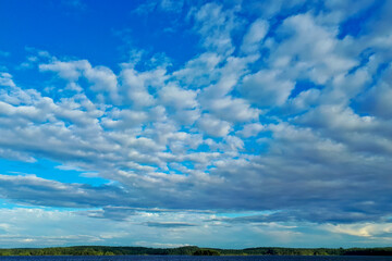 Obraz premium White fluffy clouds against a clear blue sky. Beautiful sky background