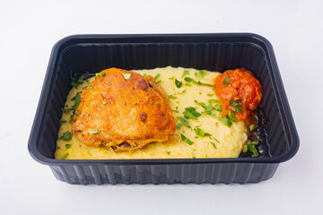 Food delivery to the office. Appetizing chicken with mashed potatoes with caviar in a disposable bowl