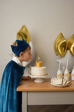 Blond boy blowing out candles at a birthday party