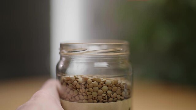 Glass jar container with dry lens unscrewing lid close-up