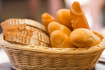 Set of different pastries crispy rolls, beer sticks and freshly baked sliced ​​bread in a wicker basket on the table.
