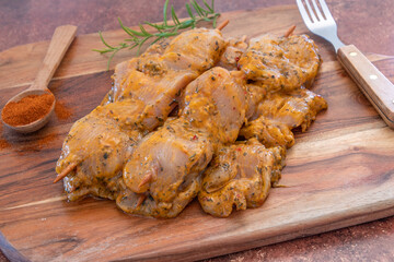brochettes de poulet crus et marinés sur une planche à découper