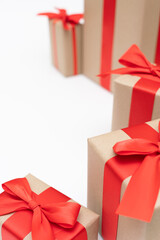 Close-up brown paper gift box red bow ribbon white background. concept for happy love gift