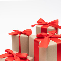 Close-up brown paper gift box red bow ribbon white background. concept for happy love gift