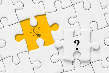 Fototapeta premium Creative idea or problem solving concept, question mark and light bulb icon on jigsaw puzzle, jigsaw puzzle with missing piece