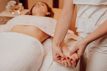 Obraz na płótnie Canvas Beautician massaging hand of female in the spa salon, lifestyle and healthcare concept