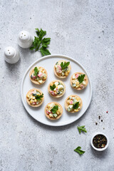 .Salad with crab meat and corn in tartlets on a concrete background.