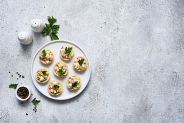 .Salad with crab meat and corn in tartlets on a concrete background.