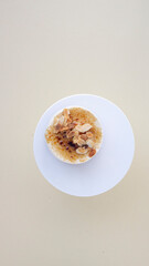Caramel cake with almonds. On a round cake stand and a light background.