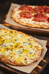 Two Roman-style pizzas with cheese and bacon. Roman square pizza or Pinsa on a thick dough, Italian Cuisine