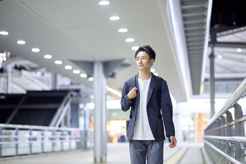 Fototapeta premium 若いビジネスマンと夜の駅