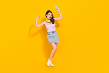Fototapeta na wymiar Full body photo of overjoyed satisfied lady hold telephone dancing isolated on yellow color background