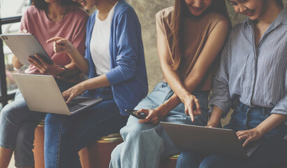 Beautiful Asian woman using smartphone, laptop and tablet in office during office meeting