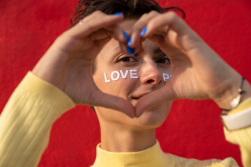 Woman gesturing heart with hands in front of face with text