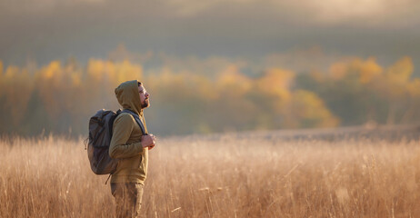 Young handsome man posing in autumn forest.