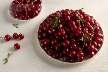 ripe cherries in a plate on a light background