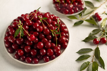ripe cherries in a plate on a light background