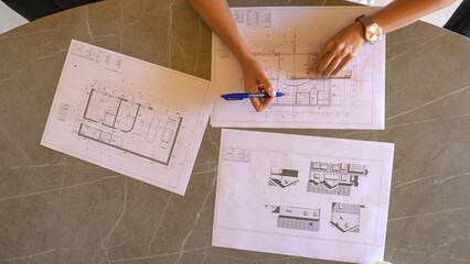 TOP DOWN: Female feng shui expert drawing energy lines on house building plan - obrazy, fototapety, plakaty