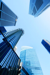 low angle view of singapore city buildings against blue sky 