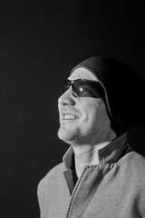 a man on a dark background with glasses