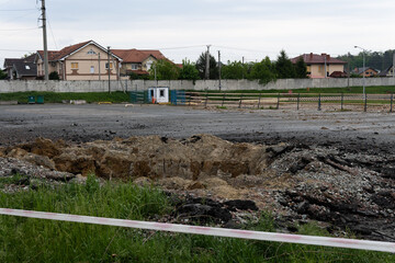 A hole in the ground from a cannon explosion of a Russian shell in the Kyiv region in Ukraine 2022....