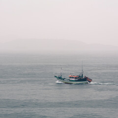 Fototapeta premium A small fishing boat cruising the bay of the town of Angra dos Reis, State of Rio de Janeiro, Brazil. Taken with Nikon D750 24-120 lens, at 85mm, 1/80 f 8.0 ISO 100. Date: Jan 05, 2018.