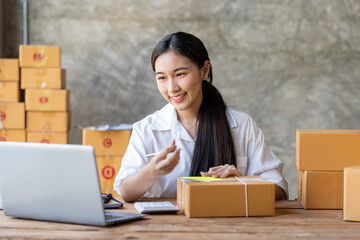 Young Asian business woman startup sme small business entrepreneur SME distribution warehouse with parcel mail box. SME Online marketing and product packaging and delivery service.