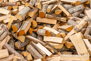 A pile of stacked firewood, prepared for heating the house. Firewood for ready heating in winter.Chopped firewood.environment background.