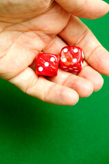 hand throwing red dice over a green table